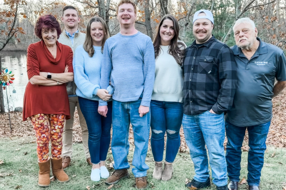 Carson and his family pose for a portrait outdoors.