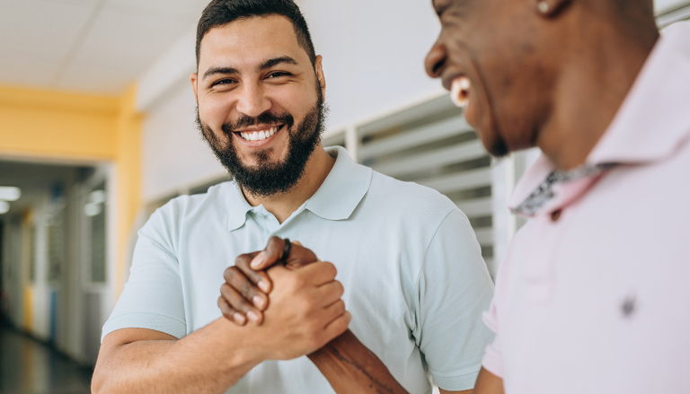 Two people shaking hands and smiling