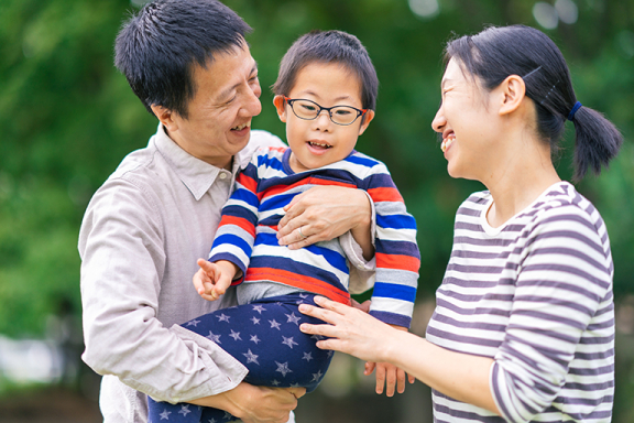Mother and father holding their young son smiling