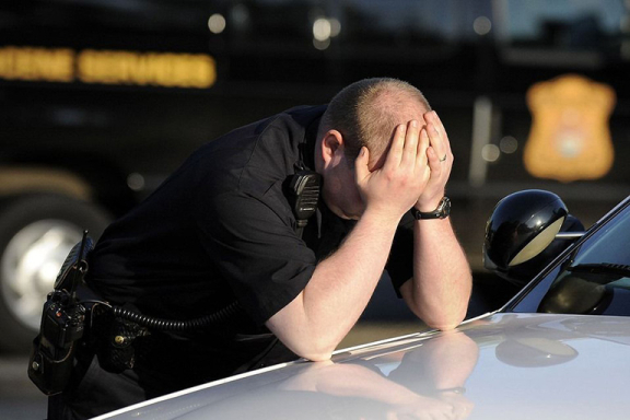 Police officer standing with head in hands