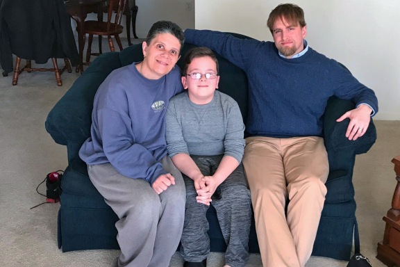 Mother and her son sitting on a couch with their counselor