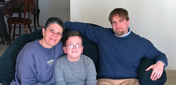 Mother and her son sitting on a couch with their counselor