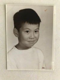 Black and white photo of smiling eight-year-old Asian child