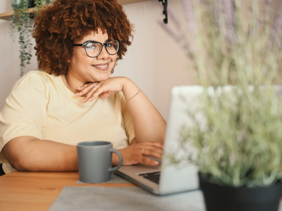 a woman sat beside her laptop computer